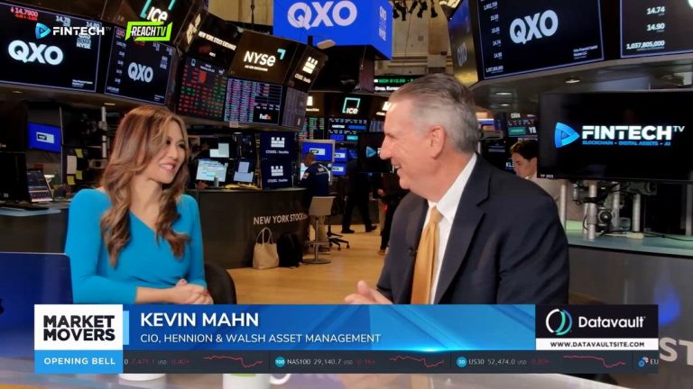 On the NYSE trading floor, Kevin Mahn speaks with a FINTECH.TV host beside QXO screens and Market Movers: The Opening Bell graphics.